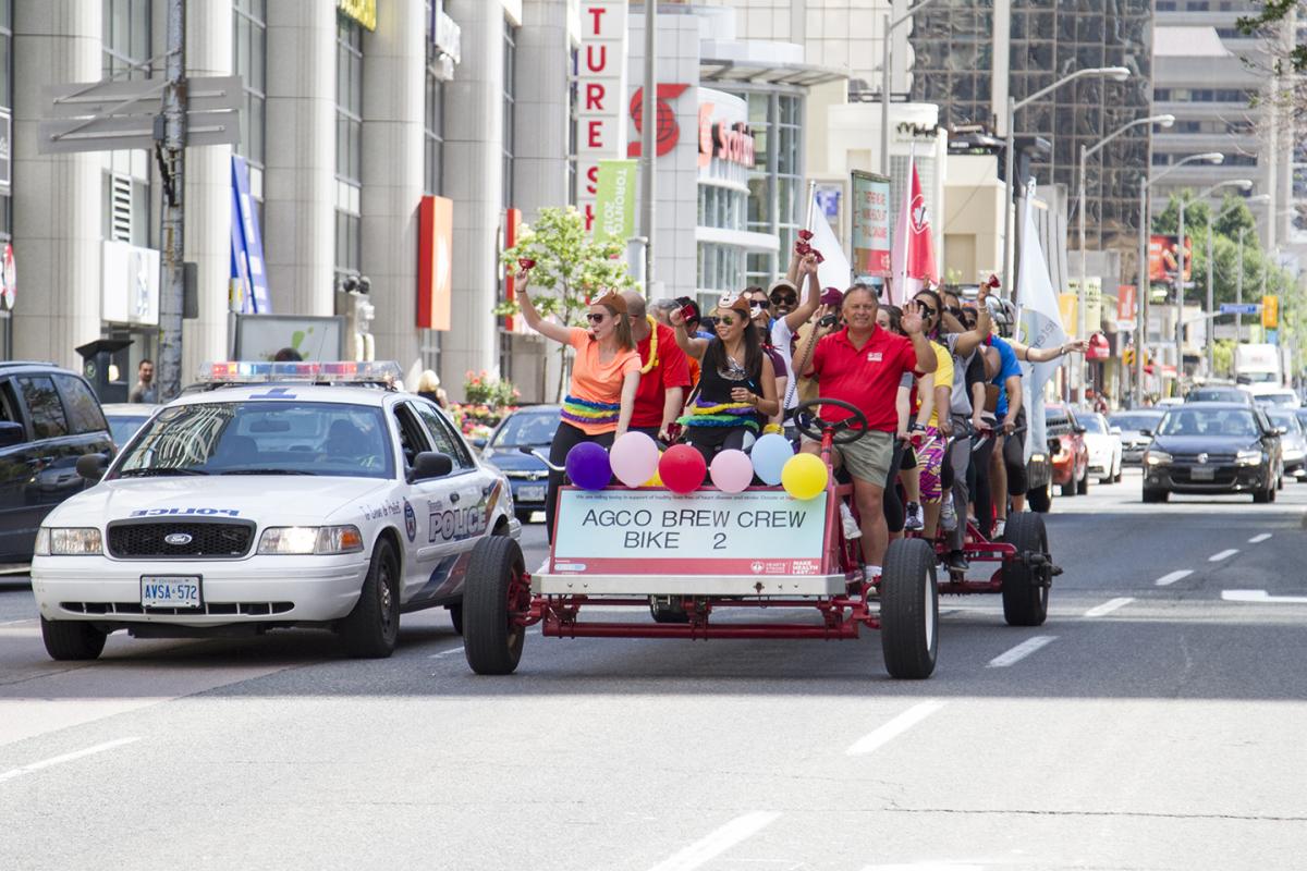 Picture of a human powered vehicle carrying a group of AGCO employees during a fundraiser activity on the streets of Toronto.